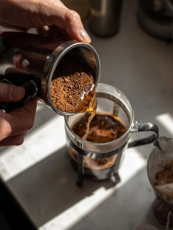 Adding coarse-ground coffee to the French press
